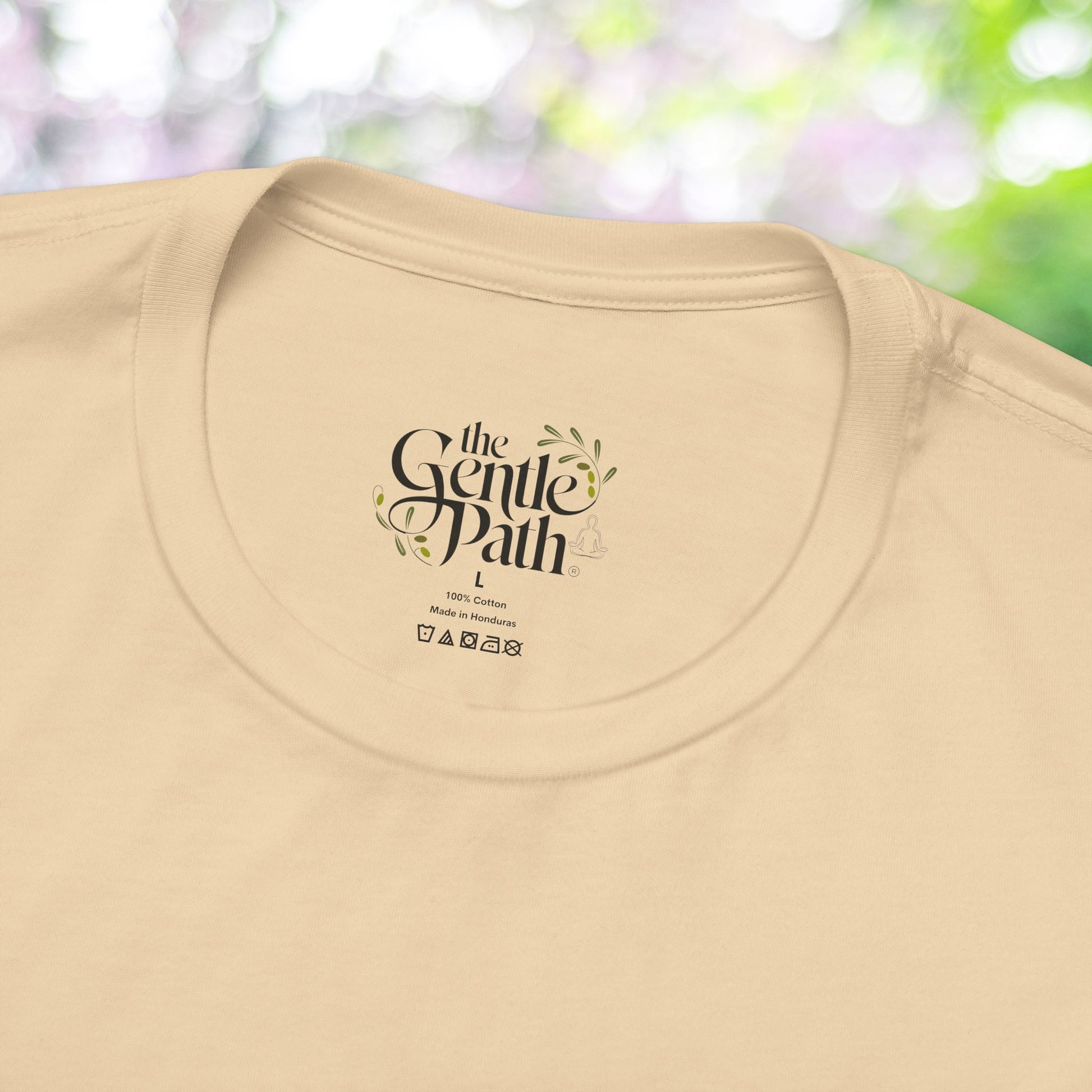 Close-up of a beige t-shirt featuring self-care brand logo.