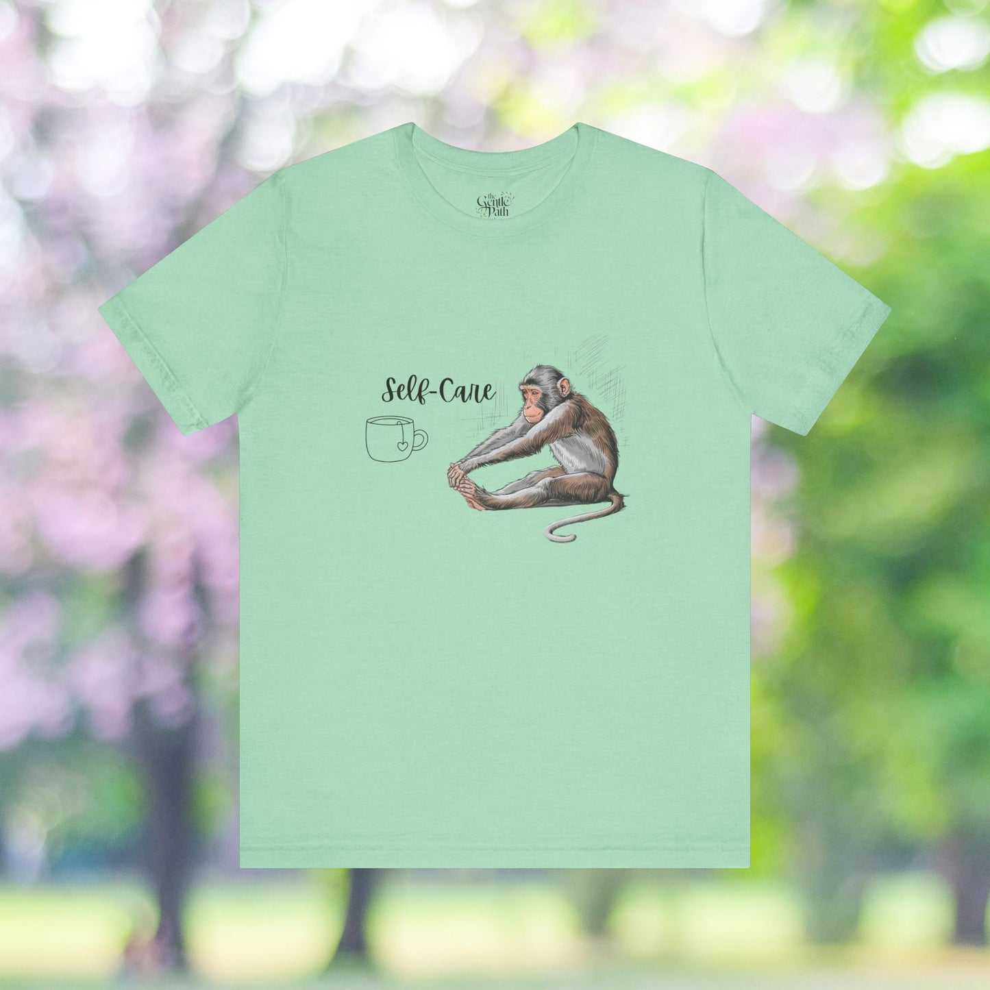 Light green tee with yoga monkey and self-care graphic