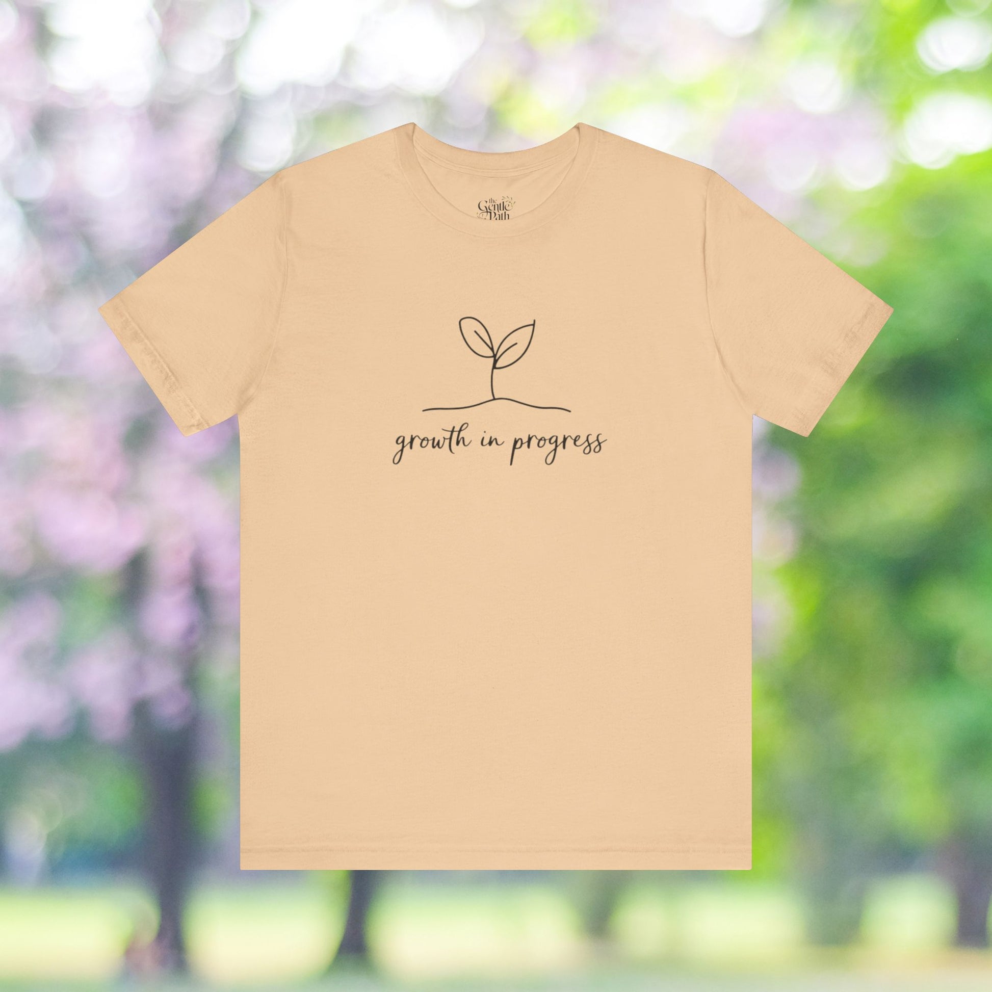 Beige unisex tee with growth in progress design.