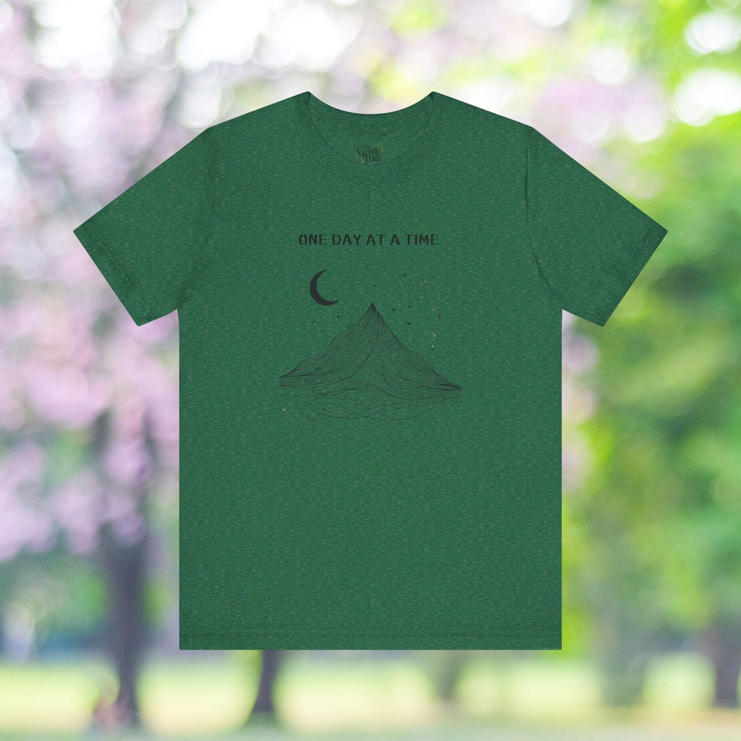 Green tee with moon, stars and minimalist mountain design.