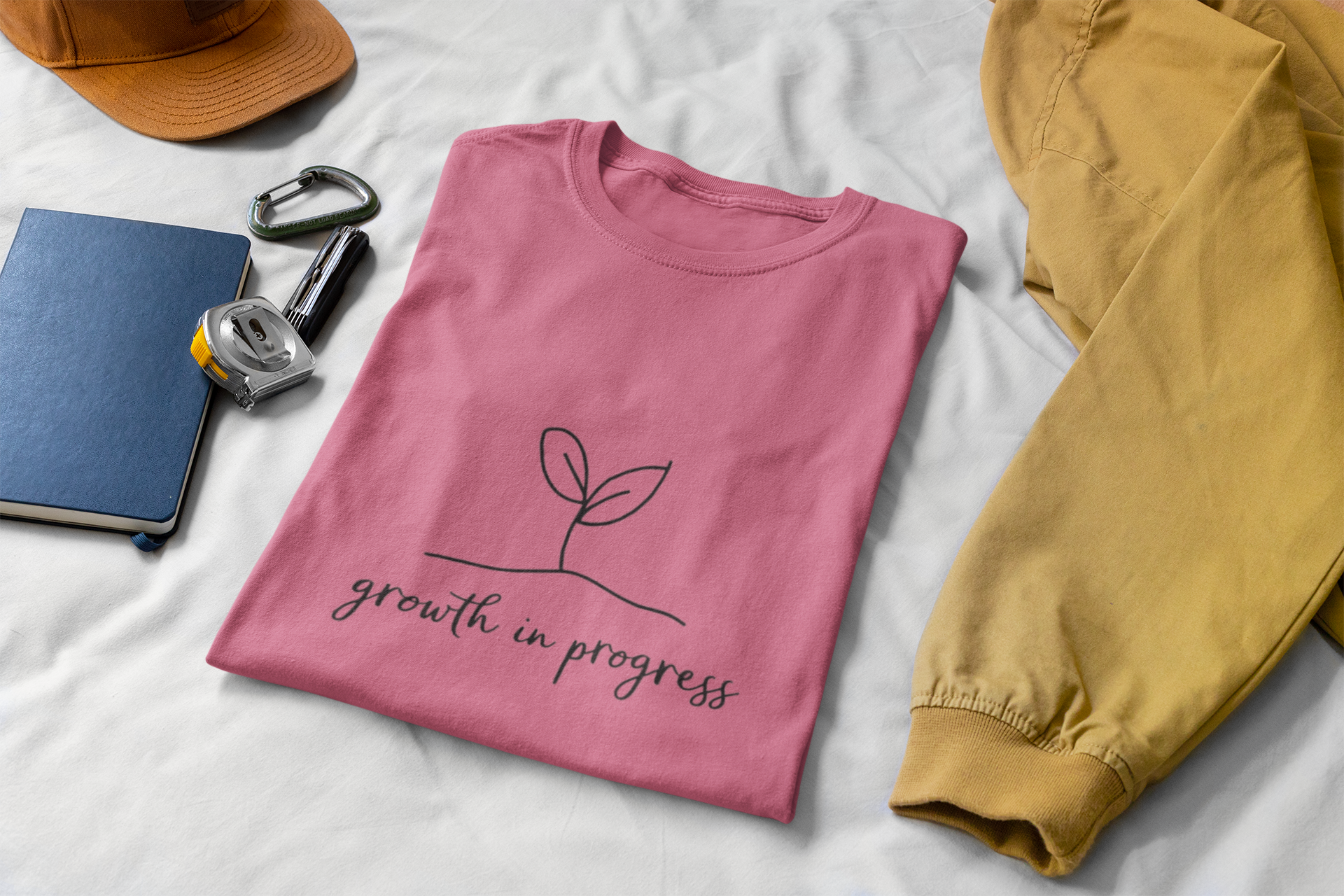 Pink unisex tee with growth in progress plant design.