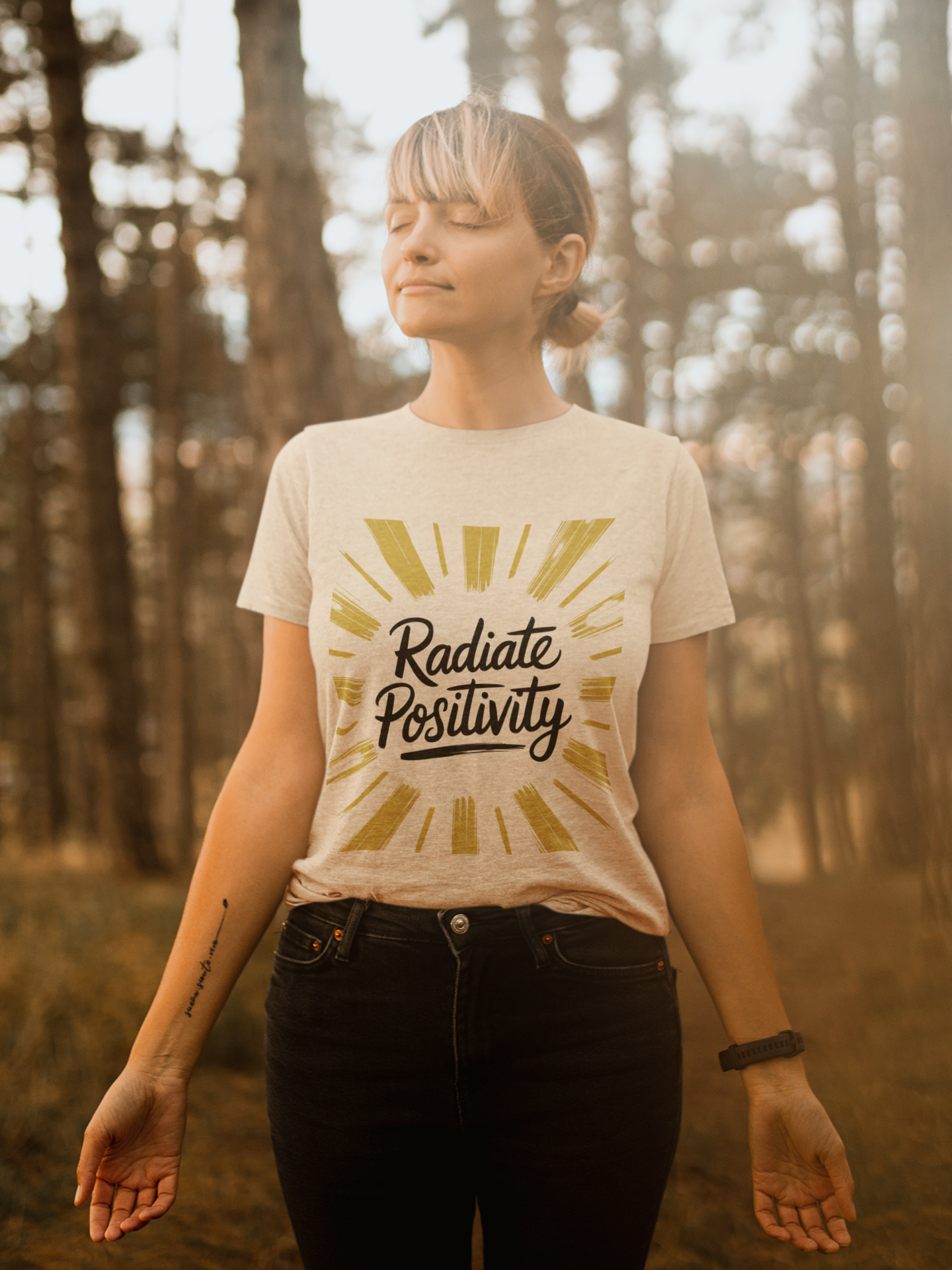 Woman wearing Radiate Positivity tee with gold sunburst design.