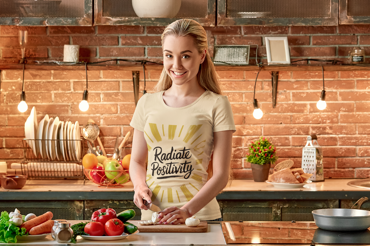 Woman wears positivity tee while cooking in her kitchen