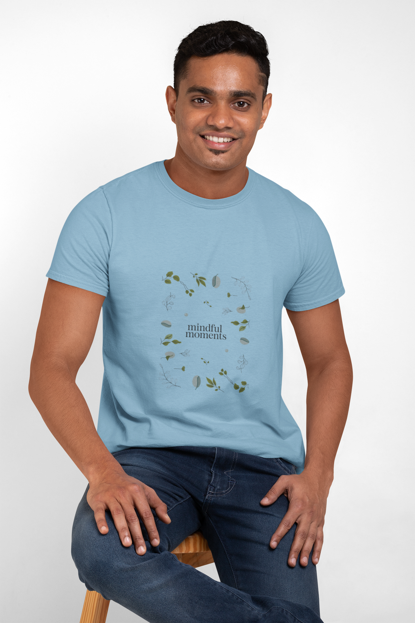 Man wearing light blue mindful moments graphic t-shirt.