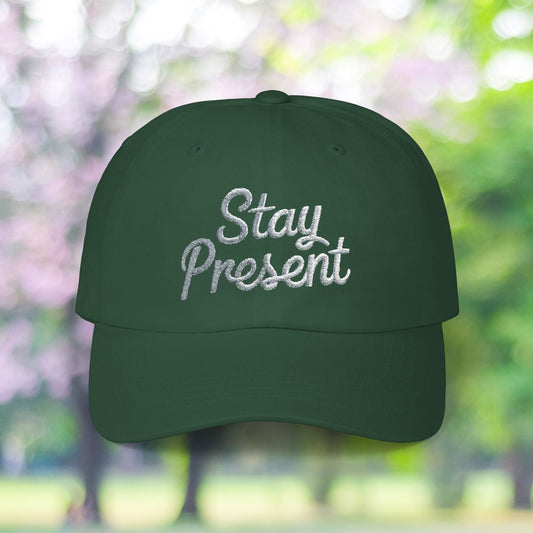 Green vintage baseball hat with 'Stay Present' embroidery.