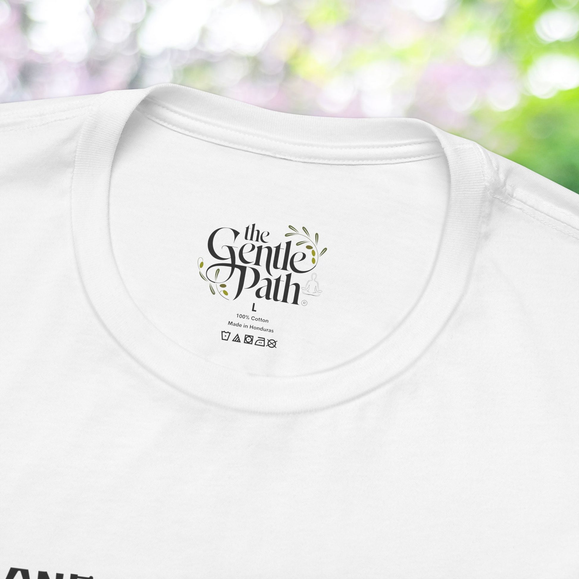 Close-up of a white tee with a 'Gentle Path' logo; self-care shirt.