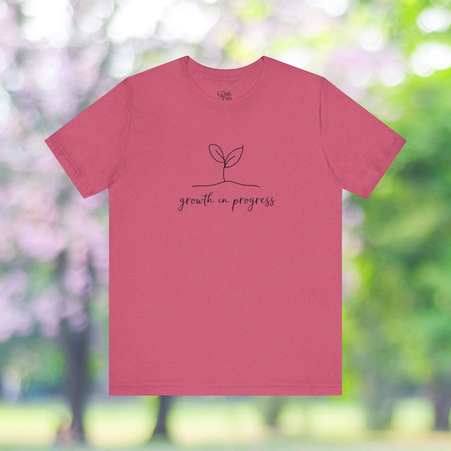 Pink tee with 'growth in progress' minimalist design.