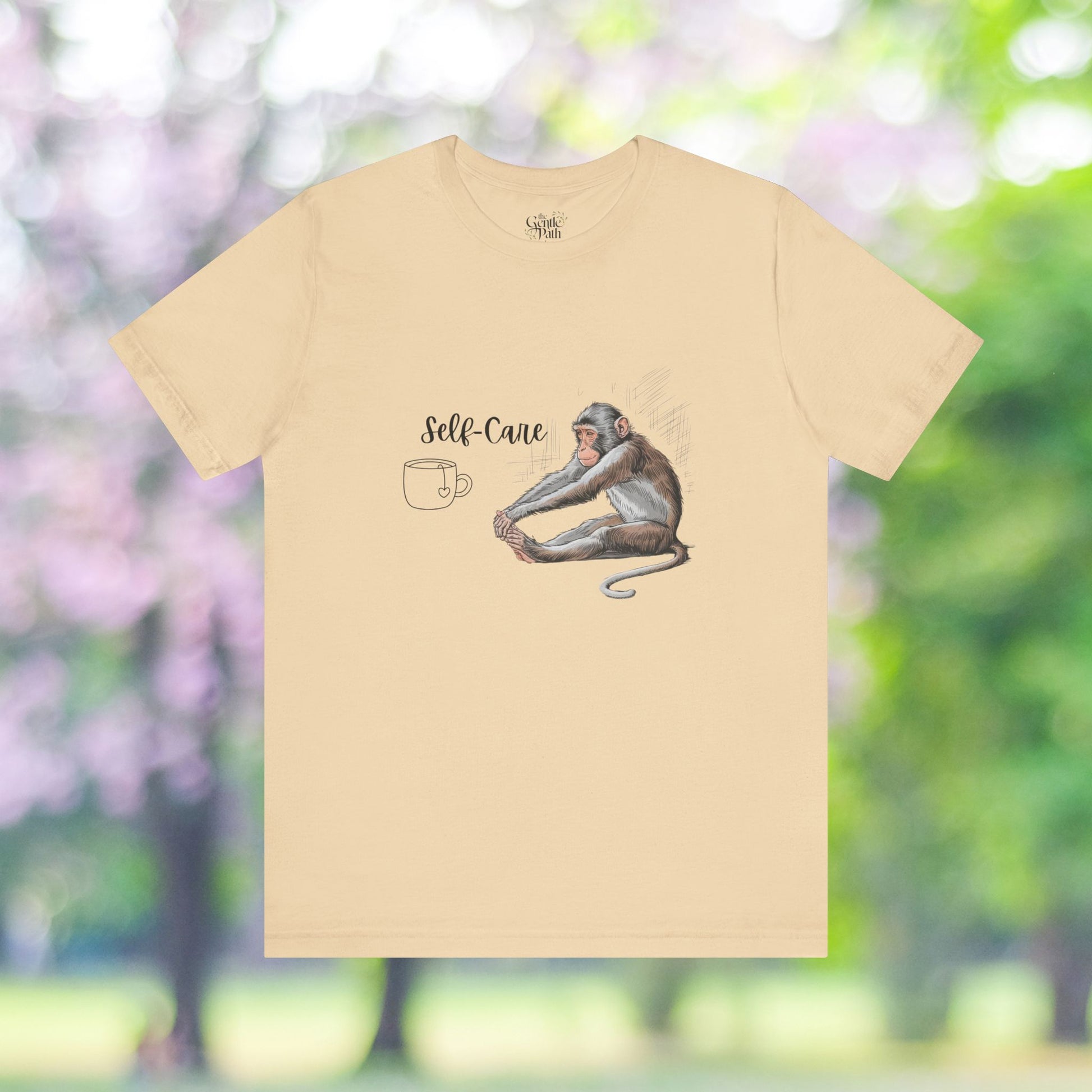 Yoga monkey with self-care text on a beige t-shirt.