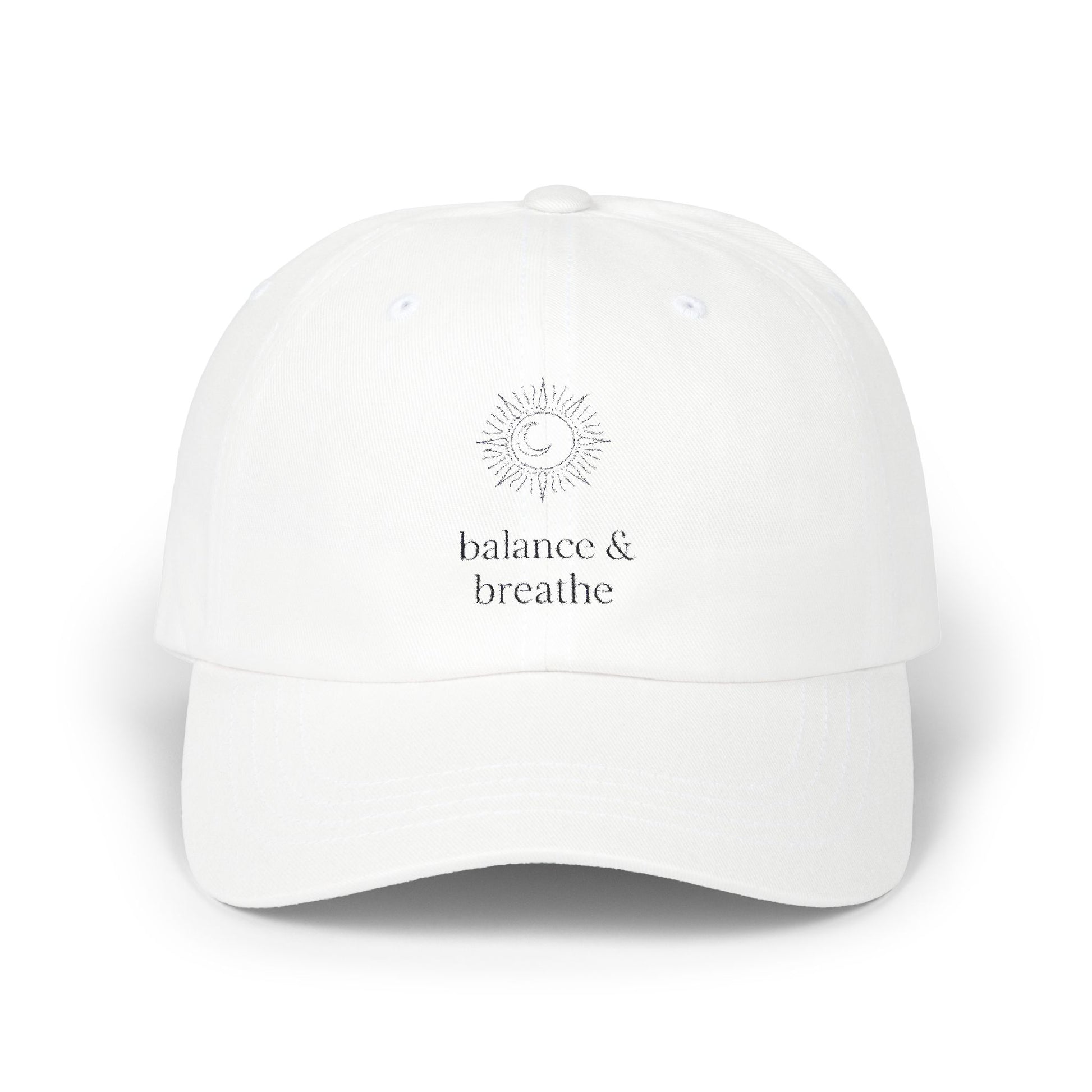 White cap with celestial sun, moon, and balance breathe embroidery.