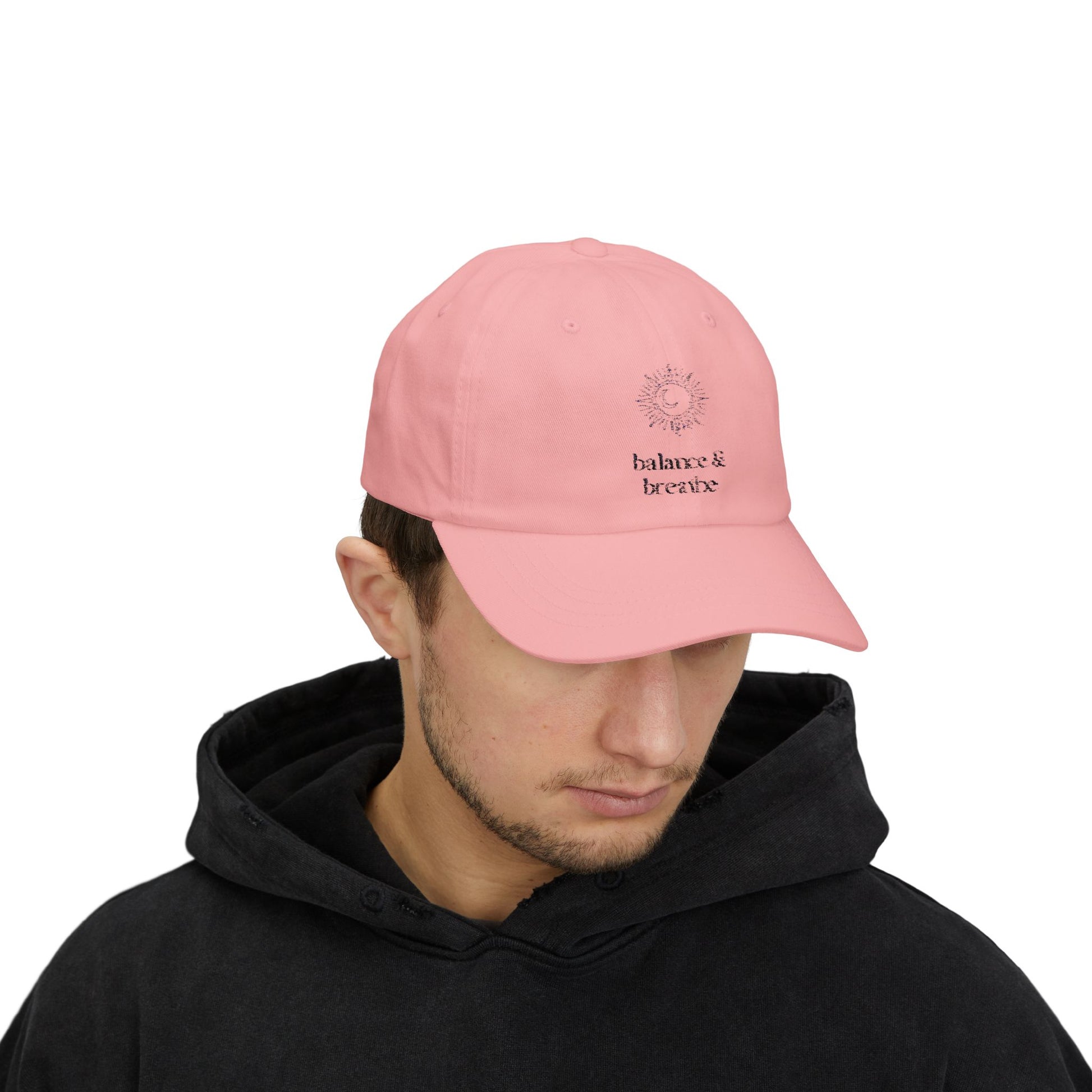 Pink hat with embroidered balance breathe celestial design.